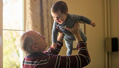 elderly man holding a baby