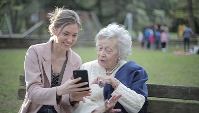 woman sitting with elderly in a park