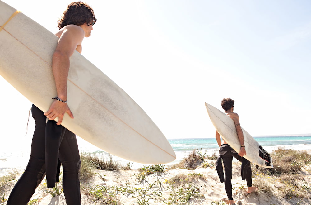 Two young surfers walking towards the waves